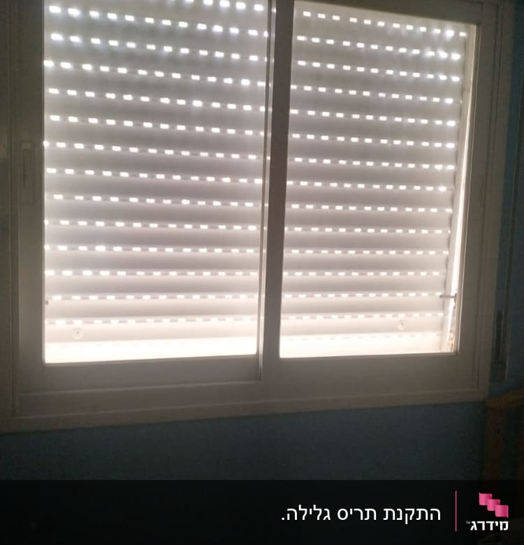 תריסים סגורים עם חריצים לאור בחלון כפול